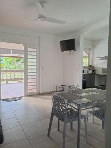 a dining room with a table and a tv on the wall at Logement de 100 m carré in Rémire-Camp