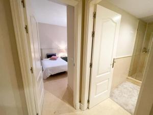 eine offene Tür zu einem Schlafzimmer mit einem Bett in der Unterkunft Luxurious 2 bedroom apartment with Spa facilities in Benahavís