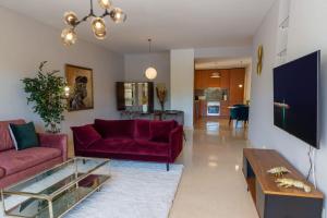 a living room with a red couch and a table at Luxurious 2 bedroom apartment with Spa facilities in Benahavís +12 photos