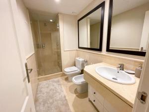 a bathroom with a sink and a toilet and a mirror at Luxurious 2 bedroom apartment with Spa facilities in Benahavís