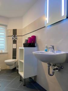 een badkamer met een wastafel en een toilet bij Gästewohnung 3 in Oschersleben