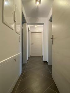 a hallway with a white door and a tile floor at Gästewohnung 3 in Oschersleben