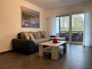 een woonkamer met een bank en een salontafel bij Gästewohnung 3 in Oschersleben