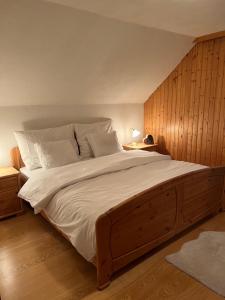 1 dormitorio con 1 cama grande y pared de madera en Das Klimachalet - CO2 neutral urlauben, en Rennweg