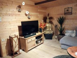 uma sala de estar com uma televisão de ecrã plano numa parede de madeira em Chalet Lisba em Comblain-la-Tour