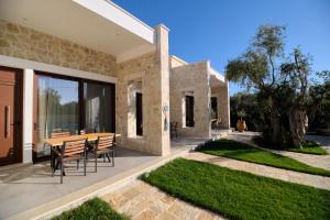 a house with a table and chairs on a patio at Zefiros Luxury Apartments in Sivota