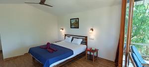 a bedroom with a bed with a red bow on it at BRAMHA COTTAGES in Canacona