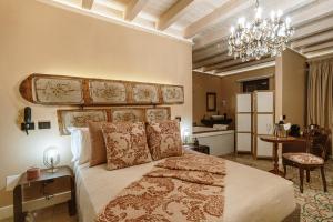 a bedroom with a large bed and a chandelier at Leano Agriresort in Piazza Armerina