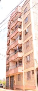 a tall apartment building with people on balconies at Crystal Apartments TRM Drive in Nairobi
