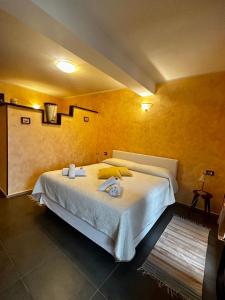 a bedroom with a large bed with towels on it at LA TAVERNA tra gli ulivi in Perinaldo
