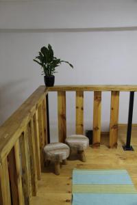 drewniana poręcz z doniczką i dwoma stołkami w obiekcie My Wooden Apartments w Tiranie