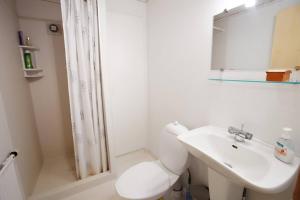 ein weißes Badezimmer mit Toilette und Waschbecken in der Unterkunft Liljulon - Views - Location in Ljósá