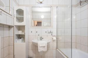 ein weißes Badezimmer mit Waschbecken und Dusche in der Unterkunft Mirage Monte Apartment in Budapest
