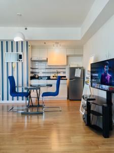 a kitchen with a table and chairs and a television at Abreeza Place by Chriza in Davao City