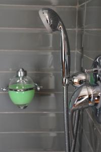 un cabezal de ducha con un tazón verde en la pared en Ca' Monteggia Guest House, en Milán