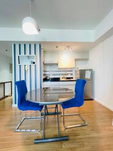 a kitchen with a table and two blue chairs at Abreeza Place by Chriza in Davao City