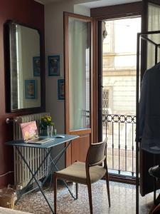Zimmer mit einem Tisch, einem Stuhl und einem Fenster in der Unterkunft Ca' Monteggia Guest House in Mailand