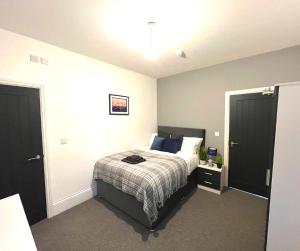 a bedroom with a bed with a striped bedspread at Chantry Suites in Grimsby