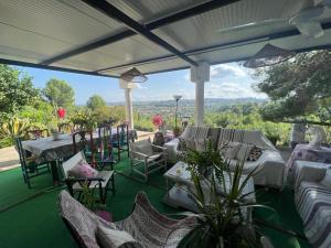 a patio with chairs and tables and a view of the mountains at VILLA VOLUBILIS in Monserrat