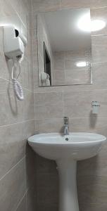 a bathroom with a white sink and a mirror at Casa Familiei in Braşov