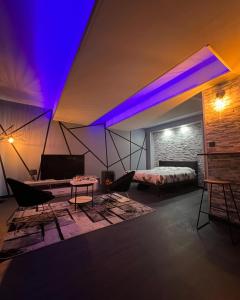 Un dormitorio con una cama con luces moradas. en The Dream Spa 07, en Tournon-sur-Rhône