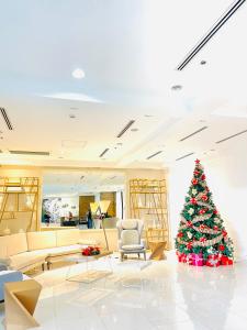 Un árbol de Navidad en medio de una sala de estar en Abreeza Place by Chriza, en Davao City