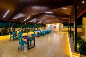 a restaurant with blue tables and chairs on a patio at Eden Garden in Alibaug