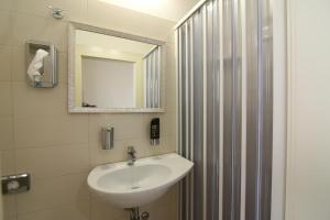 a bathroom with a sink and a shower with a mirror at Hotel Soave in Rimini