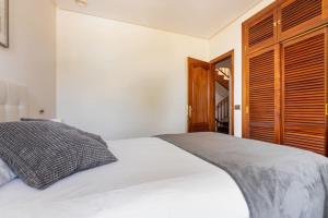 sypialnia z białym łóżkiem i drewnianymi drzwiami w obiekcie VILLA ENSUEÑO UNCETA GETARIA w mieście Getaria