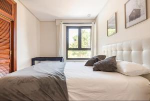 - une chambre avec un grand lit blanc et une fenêtre dans l'établissement VILLA ENSUEÑO UNCETA GETARIA, à Getaria
