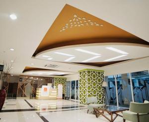 a lobby of a building with a ceiling at Grand Kamala Lagoon by Hana Room in Bekasi