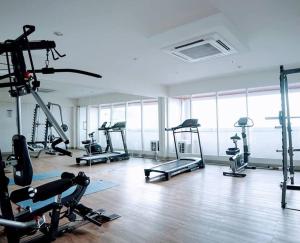 a gym with several tread machines in a room at Grand Kamala Lagoon by Hana Room in Bekasi
