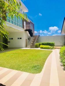 a house with a grassy yard in front of a building at Abreeza Place by Chriza in Davao City