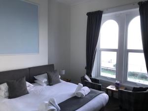 a hotel room with a bed and two windows at The Oasis in Llandudno