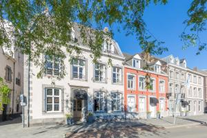 Un gran edificio blanco en una calle de la ciudad. en Amrâth Hotel Bigarré, en Maastricht