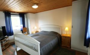 ein Schlafzimmer mit einem Bett und einer Holzdecke in der Unterkunft Holiday house in Gnosjo with amazing lake view in Gnosjö