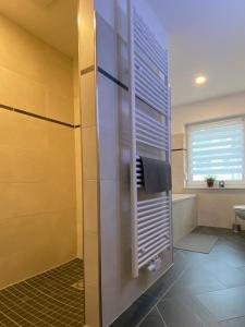 ein Bad mit einer Dusche und einem Handtuch in der Unterkunft Gästewohnung 4 in Oschersleben