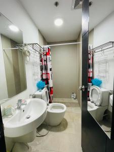 a bathroom with a white sink and a toilet at Abreeza Place by Chriza in Davao City
