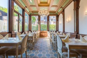 un comedor con mesas y sillas y una lámpara de araña en Amrâth Hotel Bigarré, en Maastricht