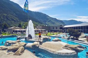 a person standing next to a fountain in a swimming pool at La Maisonnette : charmante maison indépendante in Salgesch