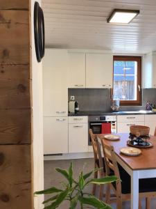 cocina con mesa, sillas, mesa y planta en La Maisonnette : charmante maison indépendante en Salgesch