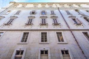- un grand bâtiment en pierre avec de nombreuses fenêtres dans l'établissement Impressive & stylish Palazzino in Valletta DDEM1-3, à La Valette