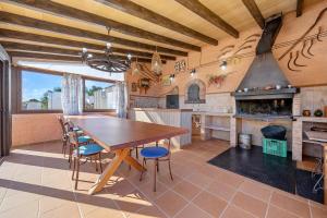 a large kitchen with a wooden table and chairs at Hauzify I Mas Bomba in Les tres Cales