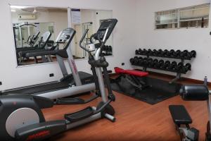 a gym with several exercise bikes and a mirror at the Waldorf Astoria 5 Alema avenue in Accra