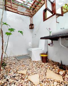 een badkamer met een stenen vloer en een wastafel bij Anacardium in Canoa Quebrada