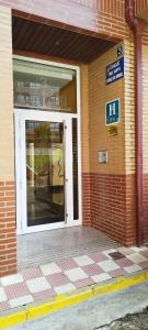 uma entrada para um edifício com uma porta de vidro em H. LAVID em Briviesca