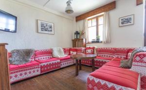 a living room with red couches and a table at Hotel Le Chamois in L'Alpe-d'Huez
