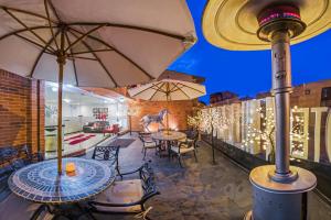 un patio avec des tables, des chaises et des parasols dans l'établissement Hotel Hill House Usaquén, à Bogotá