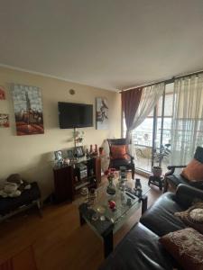 ein Wohnzimmer mit einem Sofa und einem Tisch in der Unterkunft Departamento en Condominio Cerrado La Florida in Santiago