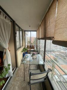 einen Balkon mit einem Tisch und Stühlen in einem Zimmer in der Unterkunft Departamento en Condominio Cerrado La Florida in Santiago